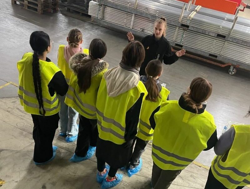 5 Eine Gruppe junger Besucherinnen in Warnwesten und Überschuhen bekommt eine Führung durch die Produktionshalle von Längle Oberflächen.