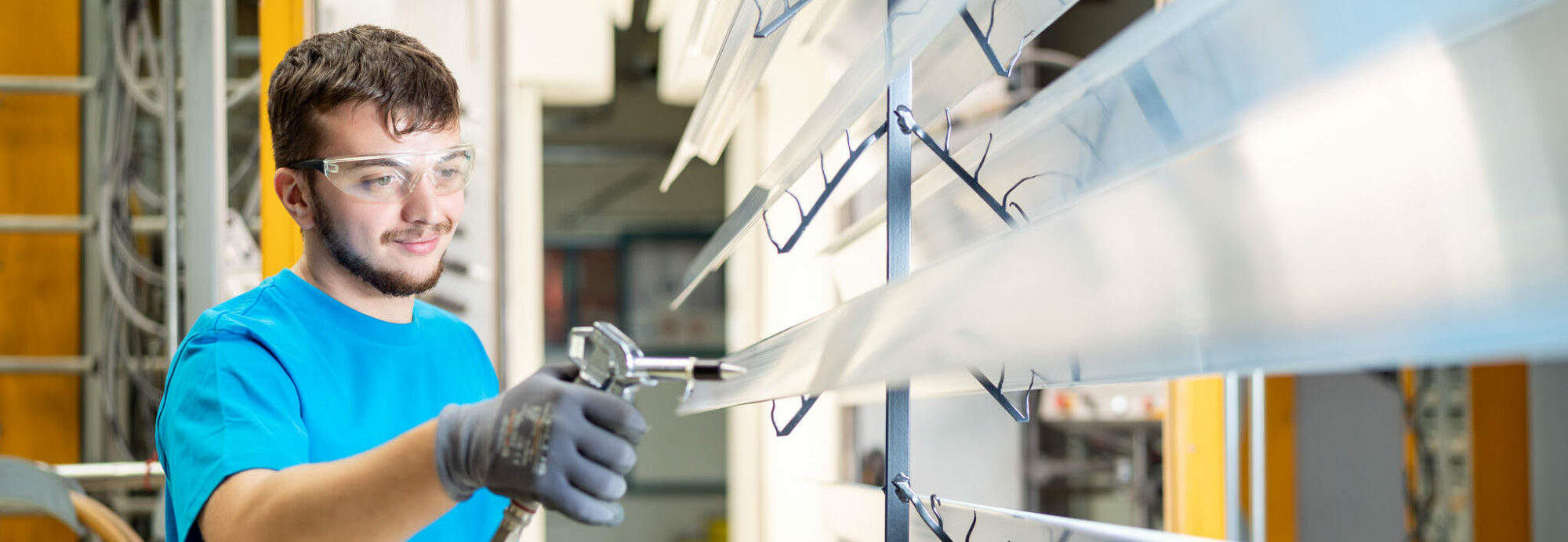 Mitarbeiter von Längle Oberflächen beim professionellen Beschichten von Metallprofilen.