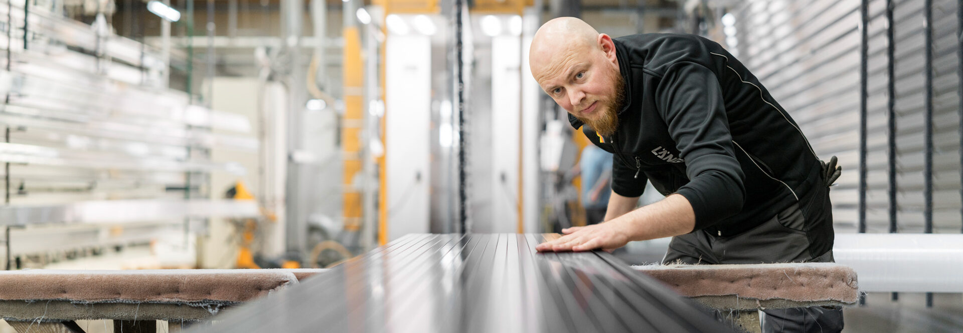 Mitarbeiter prüft eine Metalloberfläche nach der Pulverbeschichtung.