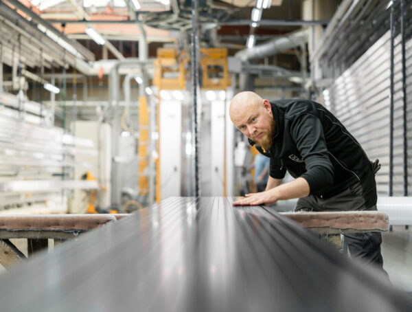 Mitarbeiter prüft eine Metalloberfläche nach der Pulverbeschichtung.