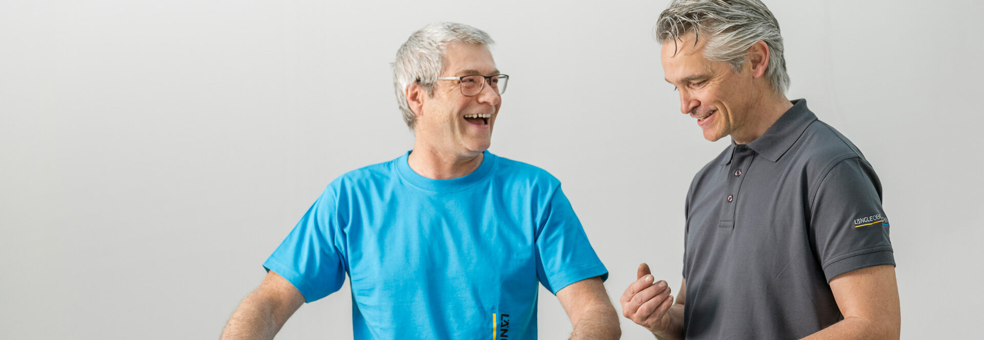 Zwei Mitarbeiter stehen an einem Tresen und führen ein freundliches Gespräch.