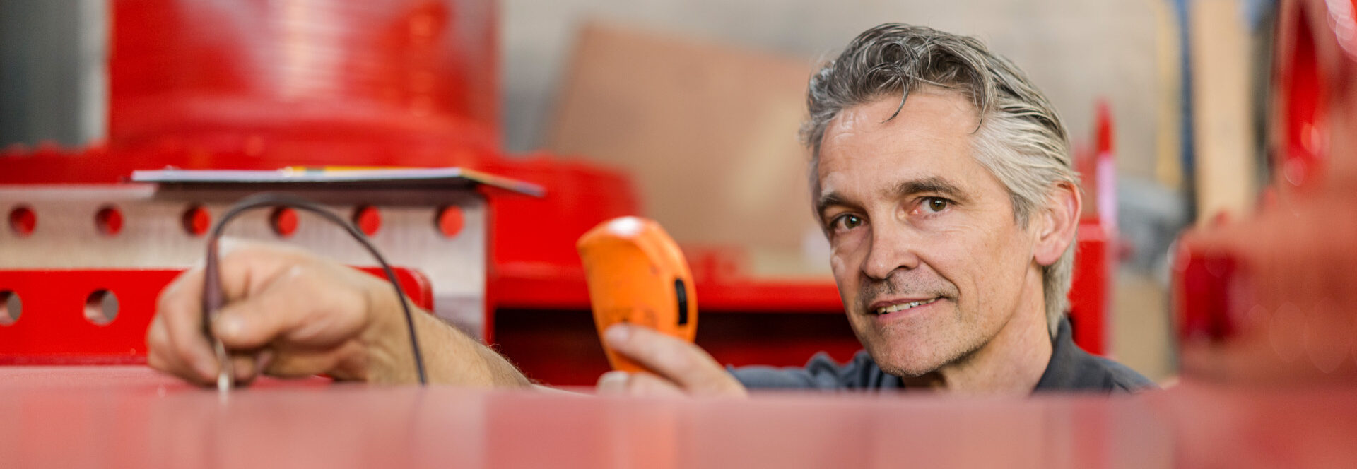 Fachmann prüft mit Messgerät die Schichtdicke einer Nasslackierung.