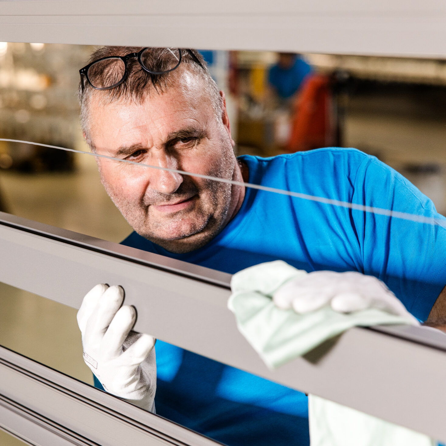 Pulverbeschichtete Oberflächen richtig reinigen und pflegen 3 Mitarbeiter von Längle Oberflächen überprüft und reinigt ein beschichtetes Aluminiumprofil für höchste Qualitätsstandards.